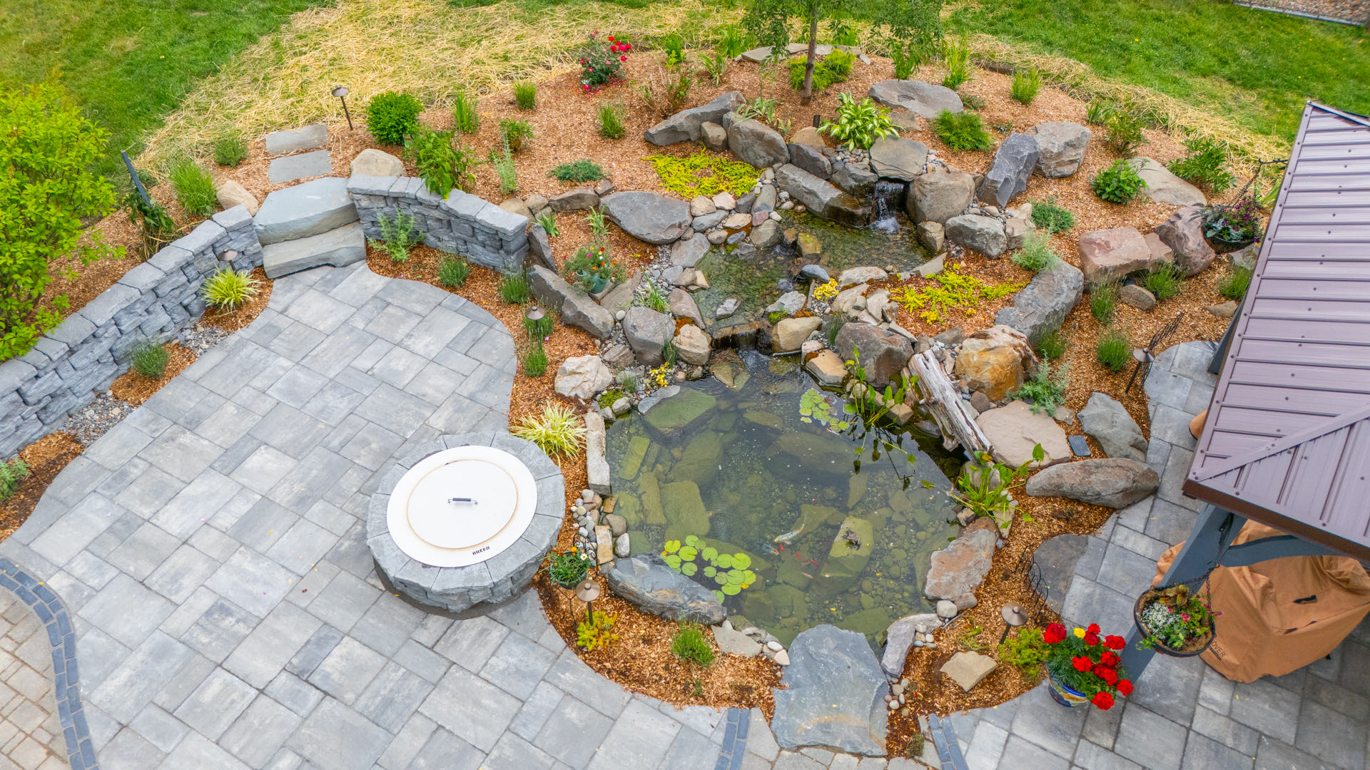 Aerial view of the unified patio, fire pit, and ecosystem pond